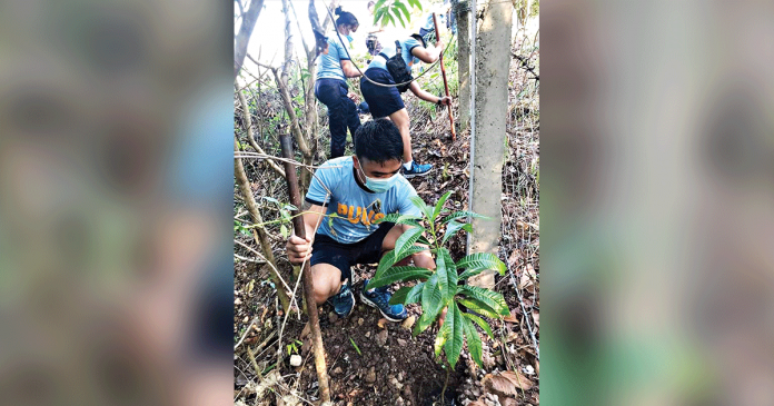 Personnel of the police station of Nueva Valencia, Guimaras plant tree seedlings as a pre-Valentine’s Day activity on Feb. 13 – their way of expressing love to Mother Earth. PHOTOS BY NUEVA VALENCIA MUNICIPAL POLICE STATION