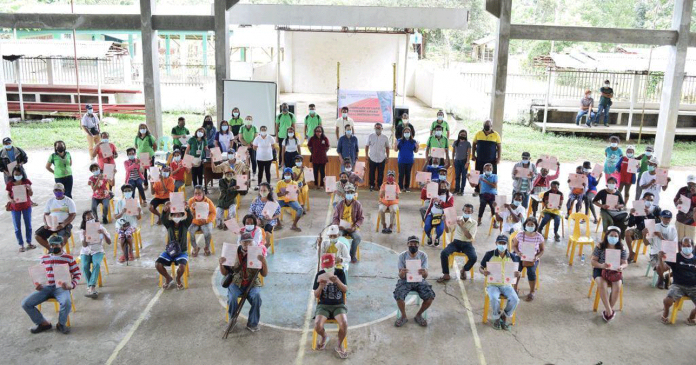 After many years of waiting, agrarian reform beneficiaries in Barangay San Nicolas, Buenavista, Guimaras are finally holding the titles to their lands issued by the Department of Agrarian Reform. They are shown here observing physical distancing during the land title distribution at the covered gym of Barangay San Nicolas.