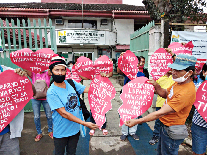 Protesting Negros Occidental farmers press the government to hasten the distribution of agrarian reform lands, during a post-Valentine rally at the provincial office of the Department of Agrarian Reform in Bacolod City.