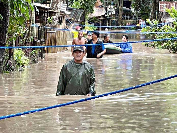 Residents of a flood-hit village in Talisay City, Negros Occidental evacuate on Feb. 22. The Office of Civil Defense Region 6 reported no casualties due to tropical depression “Auring.” PHOTO BY CDRRMO TALISAY CITY