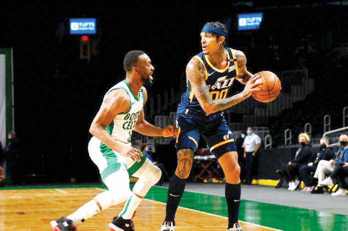 Filipino-American guard Jordan Clarkson (right) of Utah Jazz protects the ball while being barricaded by Boston Celtics' Kemba Walker (left) during their 2020-2021 NBA Season game at the TD Garden in Boston, Massachusetts. BRIAN BABINEAU/GETTY IMAGES