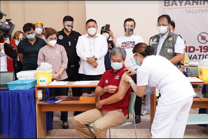 A health worker injects Sinovac’s coronavirus disease 2019 vaccine at the University of the Philippines-Philippine General Hospital director Dr. Gerardo "Gap" Legaspi in the presence of vaccine czar Carlito Galvez, Jr., Presidential spokesperson Harry Roque, and Manila mayor Isko Moreno. PCOO