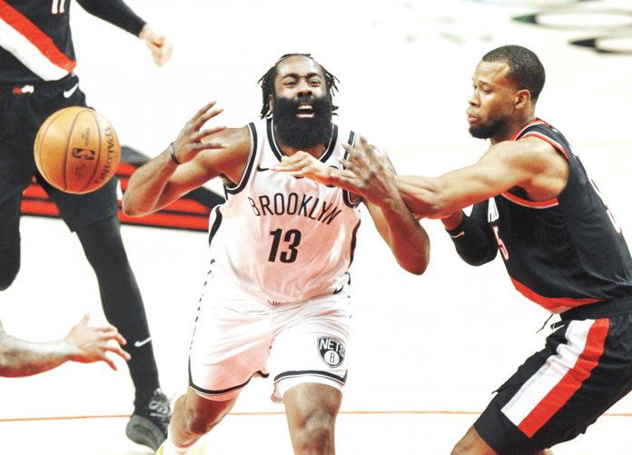 Brooklyn Nets' James Harden (left) loses the ball after being hacked by Portland Trail Blazers' Rodney Hood (right) during the first half of the NBA basketball game in Portland, Oregon. ASSOCIATED PRESS