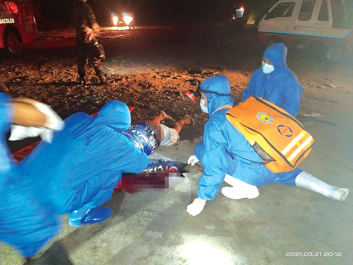 Authorities inspect the body of one of the two men who died in a road accident in Barangay Cabug, Bacolod City on March 21. BCPO