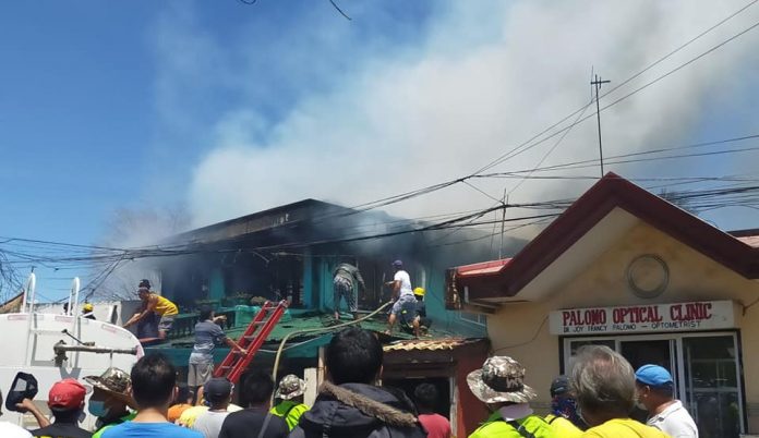 Residents and firemen attempt to put out a fire that gutted two ancestral houses in Barangay Poblacion Ilaya, Passi City, Iloilo Monday afternoon./CIO LGU PASSI