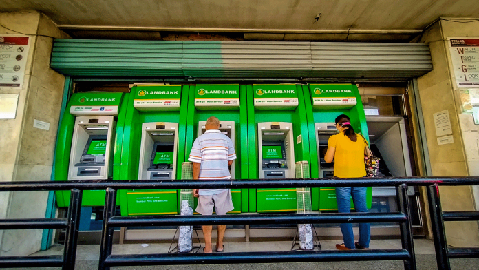 People transact at a bank’s automated teller machine terminal on Solis Street, Iloilo City. Beginning April 7, inter-bank ATM fees could go as high as P18. IAN PAUL CORDERO/PN