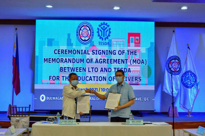 Technical Education and Skills Development Authority director general secretary Isidro Lapeña (left) do fist bump with Land Transportation Office assistant secretary Edgar Galvante (right) after the signing of a memorandum of agreement which aims to strengthen driver’s education in the country. DEPARTMENT OF TRANSPORTATION-PHILIPPINES/FACEBOOK