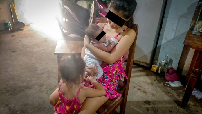 ‘CHILD HAVING A CHILD.’ Nene, 17, cradles her baby while her other daughter seeks her attention, too. Having a child at a very young age could pose high risks, an expert shares. IAN PAUL CORDERO/PN