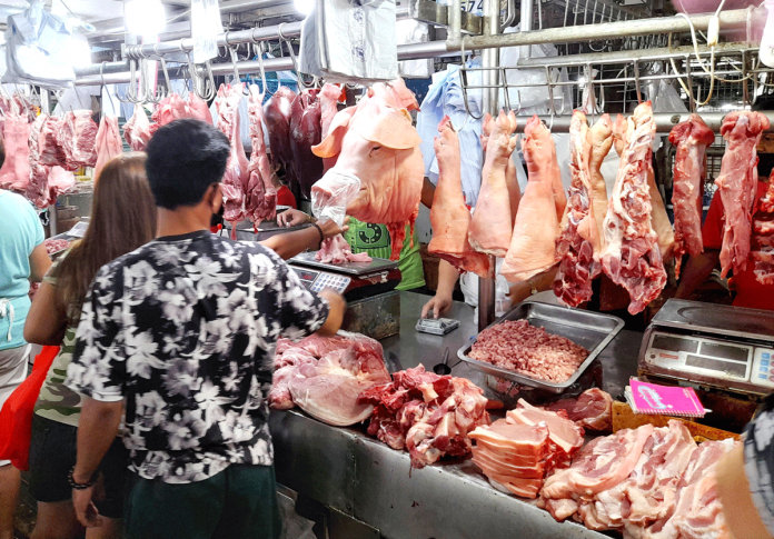 A customer weighs pork meat at a market stall that also sells processed meat products. The government has imposed a price ceiling on pork and chicken products amid high prices of these commodities. PNA/RICO H. BORJA