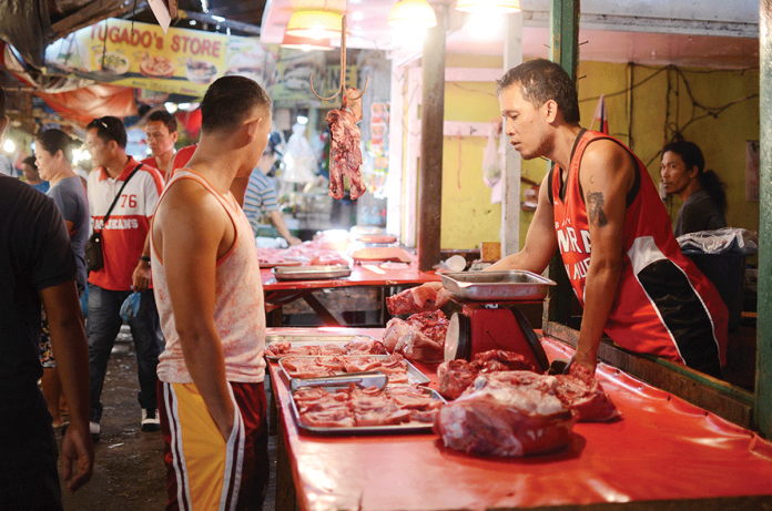 A meat vendor sells pork to a customer. In Negros Occidental, the Provincial Veterinary Office monitors a slight drop in the average price of pork from March 15 to 21. PN FILE PHOTO