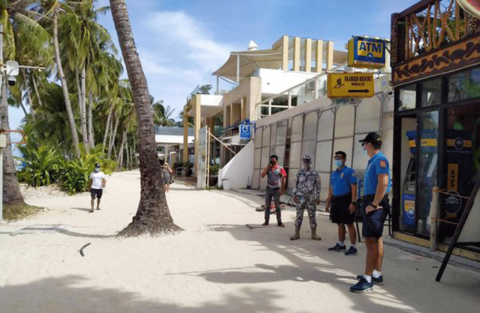 Tourists are sparse, according to these policemen monitoring the situation of Boracay Island’s beachfront. PHOTO BY MALAY POLICE STATION