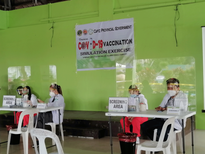 Healthcare workers wait for people to be screened during a recent coronavirus vaccination simulation organized by the provincial government of Capiz at the Poolside Pavilion of the Villareal Stadium in Roxas City. MERLINDA BAGNATE/PN