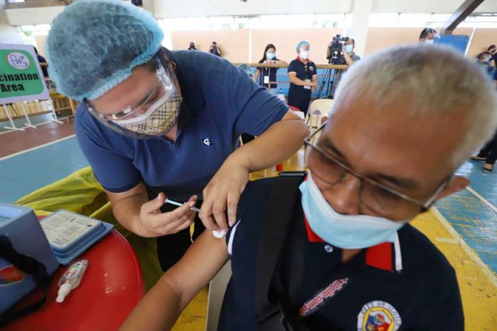 A man receives a shot of pneumonia vaccine from a healthcare worker during Iloilo City’s second coronavirus vaccination simulation exercise at the Ateneo de Iloilo gymnasium in Mandurriao district. Iloilo City is “absolutely ready” for the actual vaccination, city officials say.