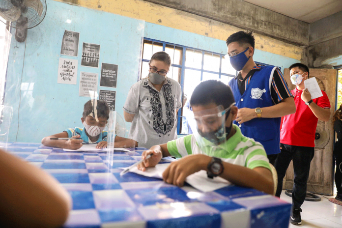 Vice President Leni Robredo watches as school children study learning modules at the Community Learning Hub that the Office of the Vice President put up in Barangay Bagacay, Tigbauan, Iloilo. The center has volunteer tutors.