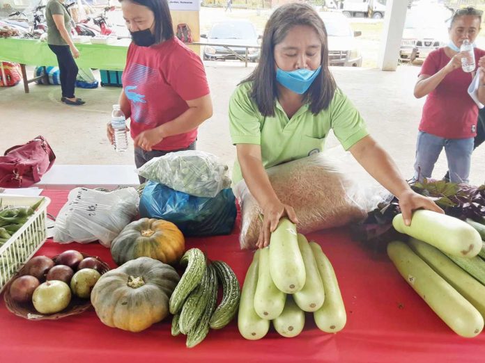 Wearing facemask, this woman displays vegetable products during the launching of KADIWA ni Ani at Kita market in Jordan, Guimaras, April 6. KADIWA market aims to help poor Filipinos in coping with the effects of pandemic. JEEOGATIS/DA-RAFIS-6