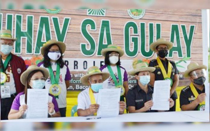 Officials led by Department of Agrarian Reform-6 Regional Director Sheila Enciso (seated, left) and Senior Supt. Gilbert Peremne (seated, right), Assistant Regional Director of Bureau of Jail Management and Penology-6, attend the launching of the “Buhay sa Gulay” project in Barangay Alangilan, Bacolod City on Monday. DAR NEGROS OCCIDENTAL I-NORTH