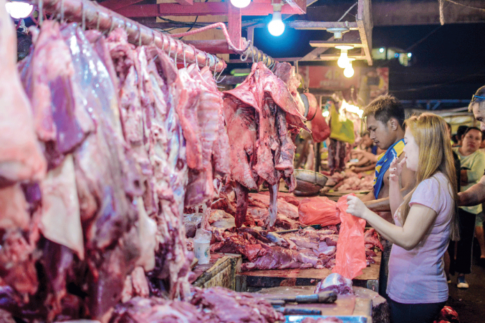 A customer buys pork at a meat stall in Iloilo Terminal Market in Iloilo City. DA-6 Executive Regional Directors Remelyn Recoter says Western Visayas remains ASF-free. She encourages everyone to help maintain the region’s status. PANAY NEWS PHOTO