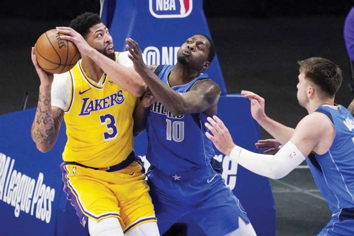 Los Angeles Lakers’ Anthony Davis (3) attempts to shoot the ball against Dallas Mavericks’ Dorian Finney-Smith (10) and Luka Doncic (right) during the first half of their basketball game in Dallas, Thursday. AP