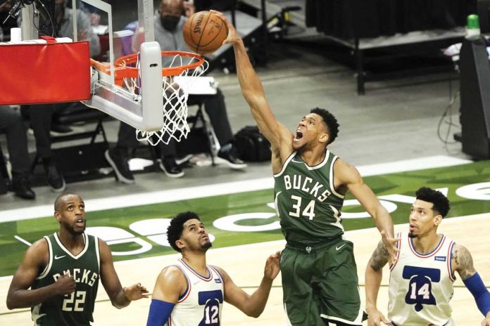 Giannis Antetokounmpo (34) of Milwaukee Bucks dunks against the Philadelphia 76ers during the second half of their basketball game, Saturday, in Milwaukee. AP PHOTO/MORRY GASH