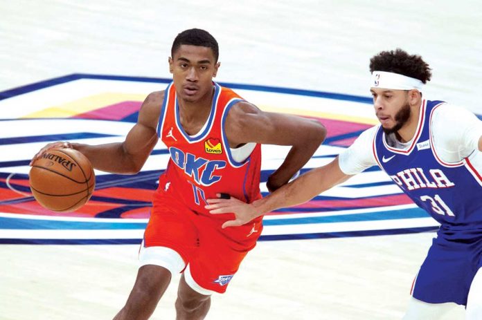 Oklahoma City Thunder’s Theo Maledon (11) dribbles past Philadelphia 76ers’ Seth Curry (31) during their game in the 2020-2021 NBA Season, Saturday, in Oklahoma City. AP/GARETT FISBECK