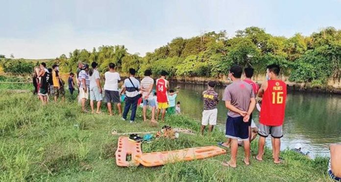 Kibitzers flock to this portion of Himoga-an River in Barangay Paraiso, Sagay City, Negros Occidental where three persons drowned on April 11. SAGAY CITY DRRMO