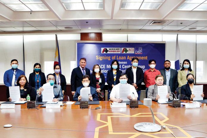 Present during the loan signing were (seated from left) DBP Senior Vice President Catherine Camarao; San Jose del Monte – Muzon Medical Center, Inc. President Dr. Diosdado Bartolo, Jr.; ACE Medical Center – Tuguegarao, Inc. Founder Dr. Carlos Fernando; DBP Executive Vice President Jose Dimayuga; ACE Medical Center Chairman Dr. Amado Manuel Enriquez, Jr.; and ACE Medical Center – Tuguegarao, Inc. President Dr. Cherry Rose T. Bañez. Joining them were other officials from DBP, ACE Medical Center – Tuguegarao Inc., and San Jose del Monte – Muzon Medical Center Inc.