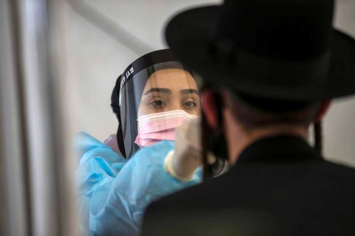 A healthcare worker takes a swab sample from an overseas returnee at Ben Gurion International Airport in Lod, Israel. The country has recorded eight cases of the virus’ Indian variant. REUTERS/RONEN ZVULUN/FILE PHOTO