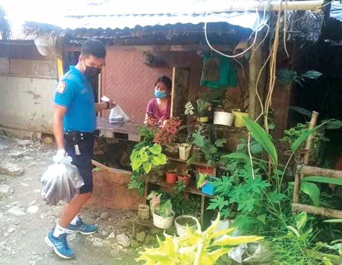 A Boracay Island policeman is distributing food packs to locked down households in Barangay Balabag. PHOTO BY MALAY AKLAN PNP