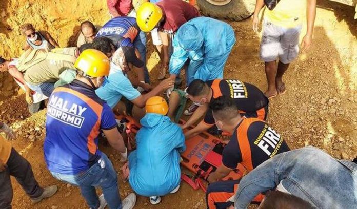 Rescuers put on a stretcher a man they pulled out from a landslide-hit area in Sitio Putol, Barangay Caticlan, Malay, Aklan on Saturday. MALAY, AKLAN BFP PHOTO