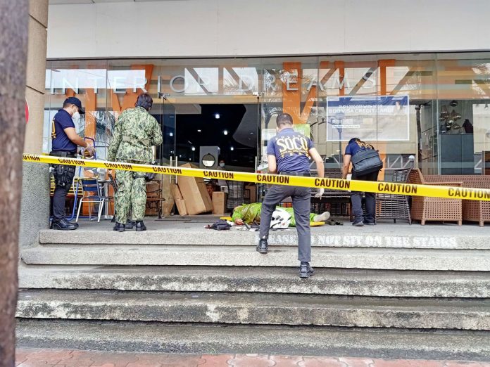 Scene of the Crime Operatives secure the body of a food delivery man who was shot to death by a bank security guard in Barangay Osmeña, Iloilo City.