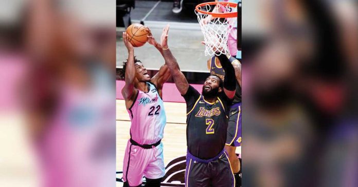 Miami Heat’s Jimmy Butler (22) attempts for a basket while Los Angeles Lakers’ Andre Drummond (2) defends during the second half of their 2020-2021 NBA Season match, April 8, at American Airlines Arena in Miami, Florida. MARTA LAVANDIER/AP