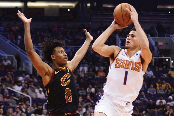 Phoenix Suns’ Devin Booker (1) drives to the basket against Cleveland Cavaliers’ Collin Sexton (2) during their basketball game on Tuesday in Ohio. The Suns prevailed over Cavaliers, 134-118, and shared the top spot in the Western Conference with Utah Jazz. JOE CAMPOREALE/USA TODAY SPORTS