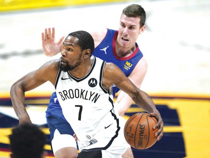 Brooklyn Nets’ Kevin Durant (7) escapes the defense of Denver Nuggets’ Vlatko Cancar during the second half of their basketball game in Denver, Colorado. The Nets snapped their four-game losing streak after a 125-119 win over the Nuggets. AP PHOTO/DAVID ZALUBOWSKI