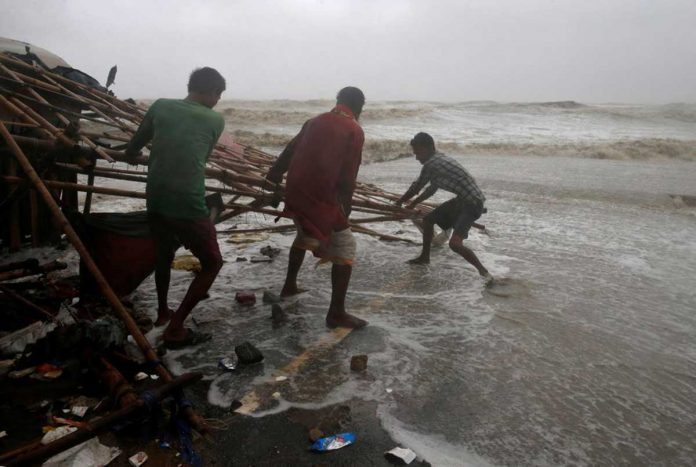 Men remove bamboo rooftop of a stall damaged by heavy winds at a shore ahead of Cyclone Yaas in Bichitrapur in Balasore district in the eastern state of Odisha India. REUTERS/RUPAK DE CHOWDHURI