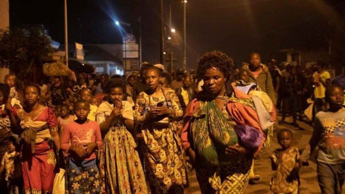 Residents carry mattresses and other belongings as they flee to safety. GETTY IMAGES