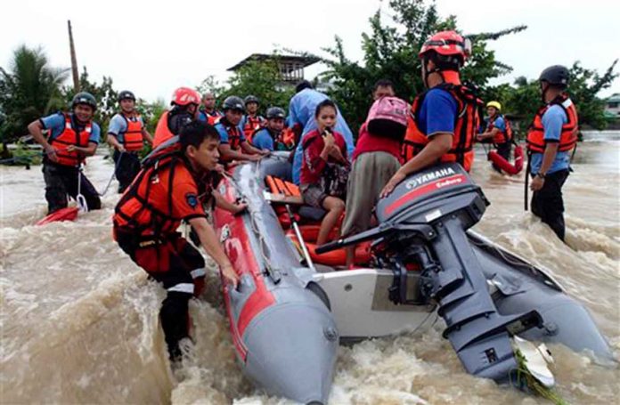 Rescuers from the Comval Emergency Response Team evacuate residents who were trapped in the flooding of Compostela Valley and nearby provinces in the southern Philippines. AP FILE PHOTO