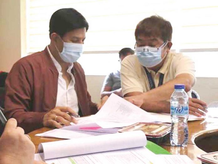 Mayor Ronnie Dadivas (left) of Roxas City goes over the details of the proposed upgrading of the city’s slaughterhouse.