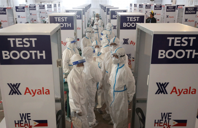 Female members of the Philippine Coast Guard in full protective gear prepare to man 66 testing booths at the Palacio de Maynila, an events venue on Roxas Boulevard that has been converted into a temporary swabbing center to expand the government’s testing capacity for the new coronavirus. The Department of Health aims to conduct 30,000 tests a day by the end of May. MARIANNE BERMUDEZ