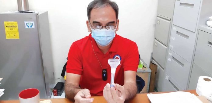 Philippine Red Cross-Iloilo Chapter administrator Gilbert Valderrama holds a Universal Transport Media COVID-19 sample collection kit used for saliva testing self-collection. Uncomfortable with nasal swabbing? Perhaps the less invasive saliva testing is for you. There are now nine specimen collection centers for this kind of test in Western Visayas. JAPHET FAJARDO/PN