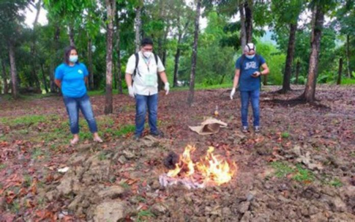 PORK PRODUCTS DISPOSED. Dr. Marco Rafael Ardamil (center), head of the Antique Provincial Veterinary Office - Public Health Division, and personnel of the Municipal Agriculture Office of San Remigio town burn pork-based food items confiscated from a restaurant on May 12. PNA, ANTIQUE PROVET