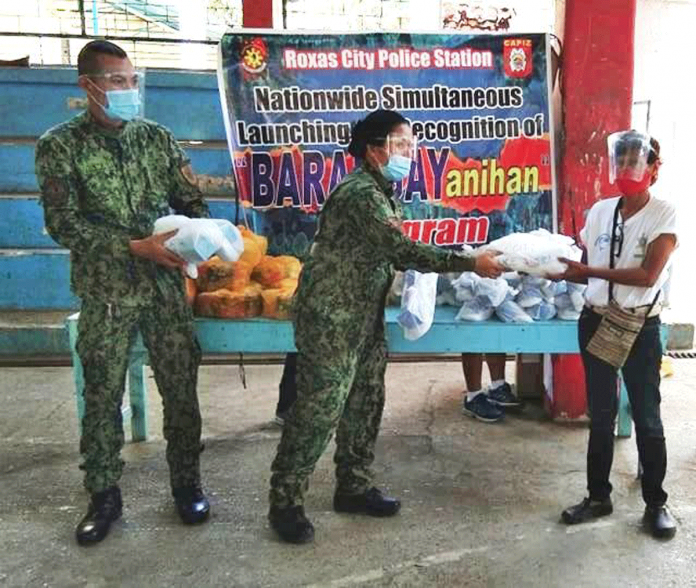 A beneficiary receives a food pack from the police station of Roxas City. Photo grabbed from Roxas City PCR FB Page