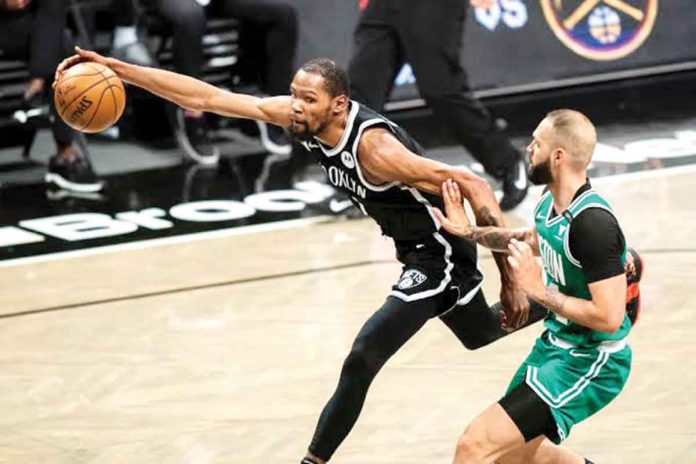 Brooklyn Nets’ Kevin Durant (left) reaches for the ball in front of Boston Celtics’ Evan Fournier during the second half of Game 1 of an NBA basketball first-round playoff series. AP PHOTO/COREY SIPKIN