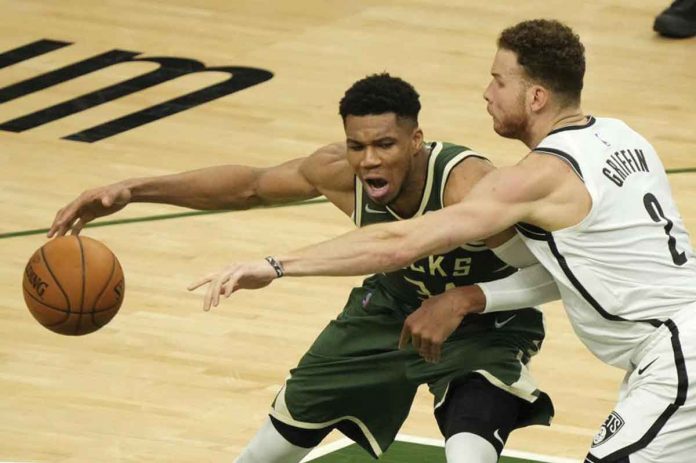 Milwaukee Bucks' Giannis Antetokounmpo (green) tries to evade the defense of Brooklyn Nets' Blake Griffin (white) during the first half of Game 3 of their Eastern Conference semifinals game on Thursday. AP PHOTO/MORRY GASH