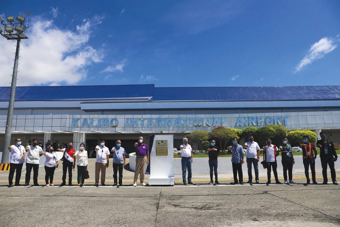 DOTr’s Secretary Arthur Tugade (middle, in violet shirt) poses with Aklan officials and representatives of various government agencies after the unveiling of the marker during the inauguration of the upgraded Kalibo International Airport on June 4, 2021. CAAP