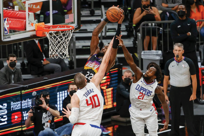 Phoenix Suns' DeAndre Ayton (22) dunks against Los Angeles Clippers' Ivica Zubac (40) and Patrick Beverley (21) during Game 2 of their Western Conference finals on Tuesday. Ayton’s last-second dunk gave the Suns a 104-103 victory over the Clippers. GETTY IMAGES