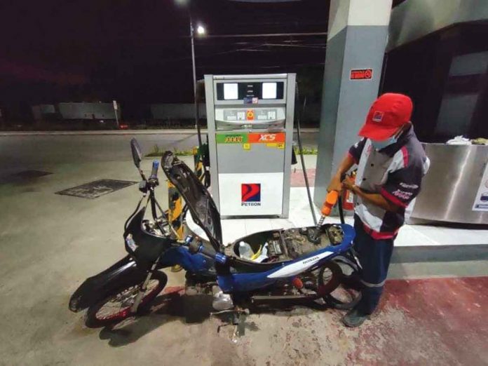 A gasoline boy refills the fuel tank of a motorcycle in a gasoline station in Pavia, Iloilo. Starting today, oil firms will impose price hike on gasoline, diesel, and kerosene. JAP FAJARDO/PN