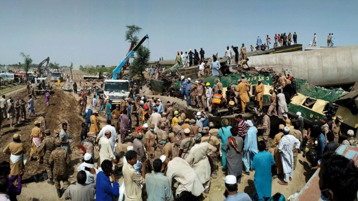 People flock to the area where two passenger trains have collided in Pakistan on Monday. At least 40 people died in the accident. REUTERS