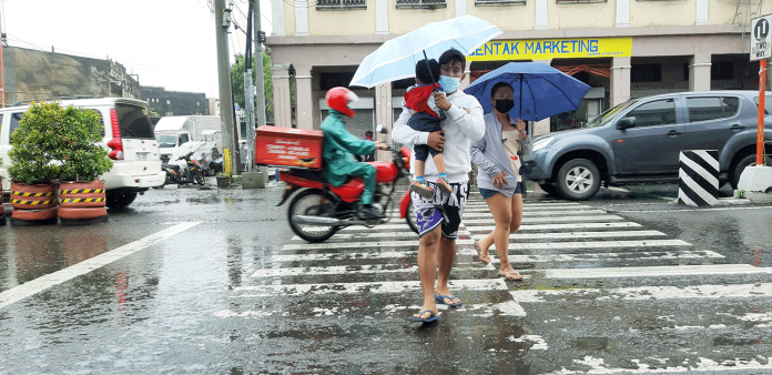 A few residents are out on a rainy day on Iznart Street, Iloilo City. The city government mulls asking the National Inter-Agency Task Force for a public health boost and tighter curbs due to rising cases of coronavirus disease 2019. JAPHET FAJARDO/PN