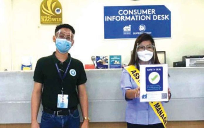 The Department of Trade and Industry-Western Visayas, through DTI -Negros Occidental Consumer Protection Unit head Romel Amihan (left), grants the Safety Seal certification to SM City Bacolod Supermarket headed by store manager Ria Ablong, on Thursday. DTI-NEGROS OCCIDENTAL