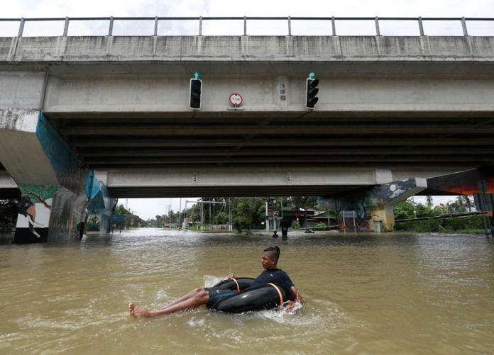 A man floats on a tube down a flooded road during a coronavirus disease 2019 curfew in Kaduwela, a suburb town of Colombo, Sri Lanka. REUTERS/DINUKA LIYANAWATTE